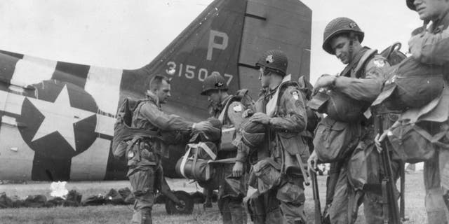 A last-minute check of equipment is made before American paratroopers leave their English base for an airborne assault on Nazi defenses on the north coast of France, June 6, 1944. Thanks to British Double Summer Time during the war, it was still daylight when paratroopers boarded planes around 11 p.m. on June 5.