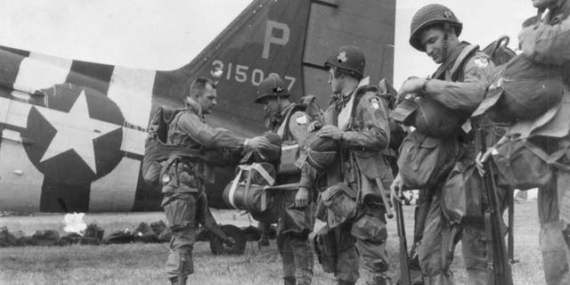 A last-minute check of equipment is made before American paratroopers leave their English base for an airborne assault on Nazi defenses on the north coast of France, June 6, 1944. Thanks to British Double Summer Time during the war, it was still daylight when paratroopers boarded planes around 11 p.m. on June 5.