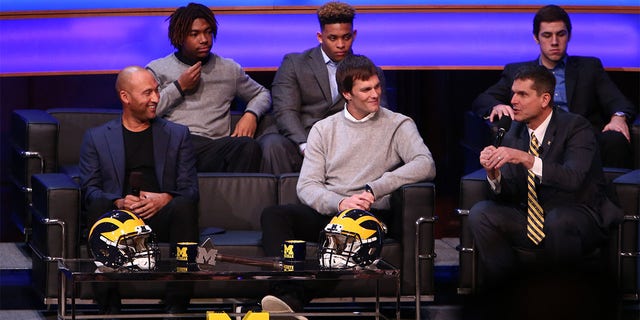 Derek Jeter, former New York Yankee, left, and Tom Brady, former Michigan Wolverine and current NFL quarterback, center, talk with Michigan Wolverines head coach Jim Harbaugh, right, during the Michigan Signing of the Stars event at Hill Auditorium on Feb. 3, 2016 in Ann Arbor, Michigan. 