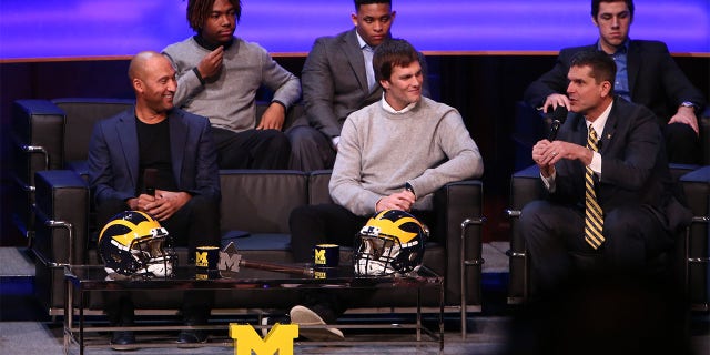 Derek Jeter, former New York Yankee, left, and Tom Brady, former Michigan Wolverine and current NFL quarterback, center, talk with Michigan Wolverines head coach Jim Harbaugh, right, during the Michigan Signing of the Stars event at Hill Auditorium on Feb. 3, 2016 in Ann Arbor, Michigan.
