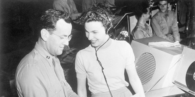 (Original Caption) 6/16/1943, New Haven, CT: Marjorie Ochs, the only girl in the show, "I Sustain The Wings," presented by the Army Forces Technical Training Command each week over a National Radio hook-up, goes over the script with Captain Glenn Miller during rehearsal to figure a means to correlate music to drama.