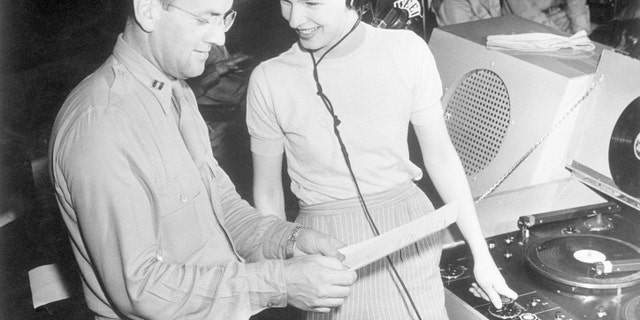 (Original Caption) 6/16/1943, New Haven, CT: Marjorie Ochs, the only girl in the show, "I Sustain The Wings," presented by the Army Forces Technical Training Command each week over a National Radio hook-up, goes over the script with Captain Glenn Miller during rehearsal to figure a means to correlate music to drama.