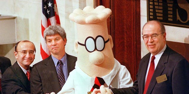 Dilbert, the comic strip character struggling to make his way up the corporate ladder, is joined by William Burleigh (R), President and Chief Executive Officer of the E.W. Scripps Company, Douglas Stern (2nd from L), Pres. and CEO of United Media, and Richard Grasso (L), Chairman of the New York Stock Exchange, to ring the opening bell.
