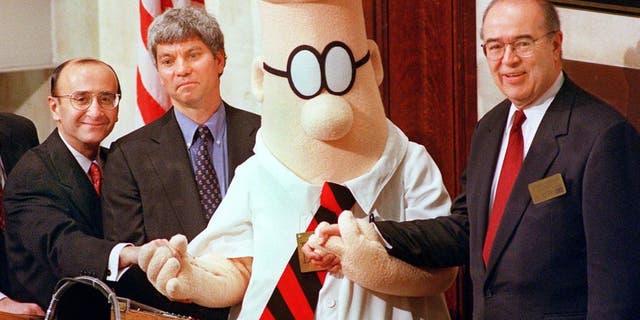 Dilbert, the comic strip character struggling to make his way up the corporate ladder, is joined by William Burleigh (R), President and Chief Executive Officer of the E.W. Scripps Company, Douglas Stern (2nd from L), Pres. and CEO of United Media, and Richard Grasso (L), Chairman of the New York Stock Exchange, to ring the opening bell.