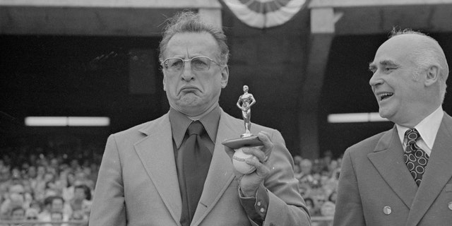 Actor George C. Scott, right, shows his feelings as he holds an "Oscar" presented to him by Oakland A's owner Charles Finley, at an Athletics-Detroit Tigers game. Scott had refused to attend the Academy Awards presentation for his Oscar awarded him for his role in "Patton."