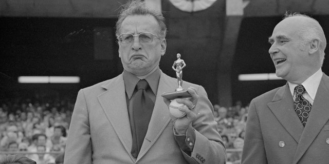 Actor George C. Scott, right, shows his feelings as he holds an "Oscar" presented to him by Oakland A's owner Charles Finley, at an Athletics-Detroit Tigers game. Scott had refused to attend the Academy Awards presentation for his Oscar awarded him for his role in "Patton."