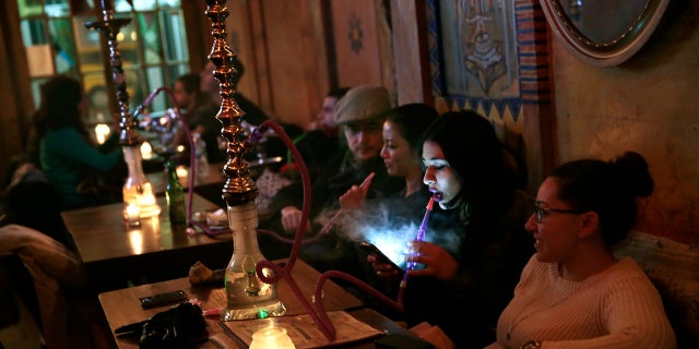 At Sahara East in the East Village area of New York City, clients puff on hookah pipes.