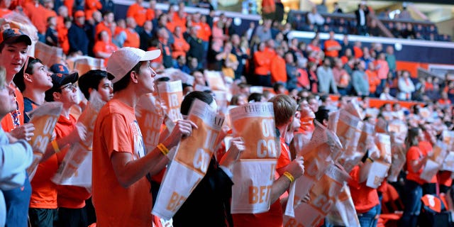 Los miembros del capítulo estudiantil de Illinois Fighting Illini Orange Krush sacuden sus periódicos Daily Illini mientras se presenta a los Iowa Hawkeyes antes del comienzo del juego de la Big Ten Conference el 25 de enero de 2017 en el State Farm Center en Champaign, Illinois. 