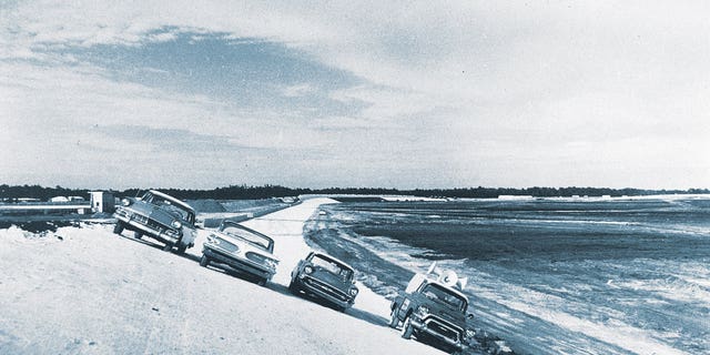 Before the asphalt was laid, Bill France Sr., and members of his NASCAR staff parked these cars on a turn of the under-construction Daytona International Speedway in December 1958. France gambled nearly everything he owned in building the facility that is known as "The World Center of Racing." 