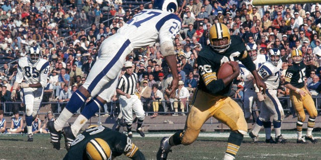 Running back Ben Wilson of the Green Bay Packers eludes cornerback Irv Cross of the Rams at the Los Angeles Memorial Coliseum on Dec. 9, 1967.