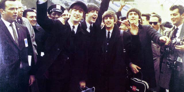 UNITED STATES - FEB. 07: (AUSTRALIA OUT): Photo of the Beatles — from left to right, John Lennon, Paul McCartney, Ringo Starr and George Harrison — waving at crowds as they arrive at JFK Airport for their first U.S. tour. 