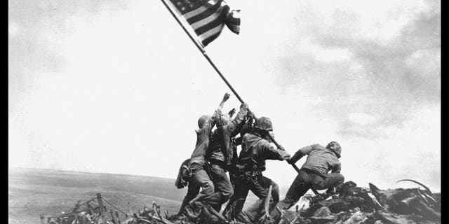 Vue des membres de la 5e division du Corps des Marines des États-Unis alors qu'ils hissent un drapeau américain sur le mont Suribachi lors de la bataille d'Iwo Jima, le 23 février 1945.
