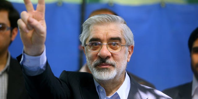 Kandidat presiden Mir Hossein Mousavi menunjukkan tanda V setelah memberikan suaranya di TPS pada 12 Juni 2009, di Teheran, Iran.  (Gambar Majid/Getty)