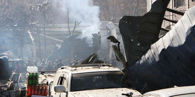 Afghan security officials inspect a blast site in Kabul, Afghanistan, Jan. 27, 2018. At least 40 people were killed and 140 others injured after a suicide car bomb blast near Sadarat Square in central Kabul.