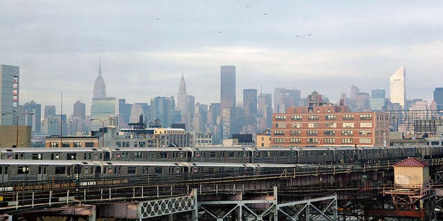 The New York City skyline behind trains arriving and departing the Queensboro Plaza subway station Dec. 23, 2005.  