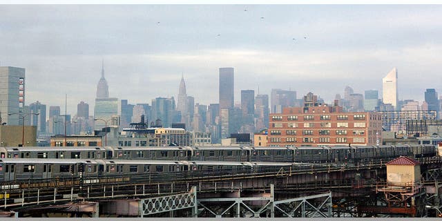 The New York City skyline behind trains arriving and departing the Queensboro Plaza subway station Dec. 23, 2005.