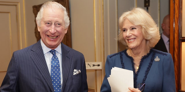King Charles III and queen consort Camilla Smiling during a royal engagement