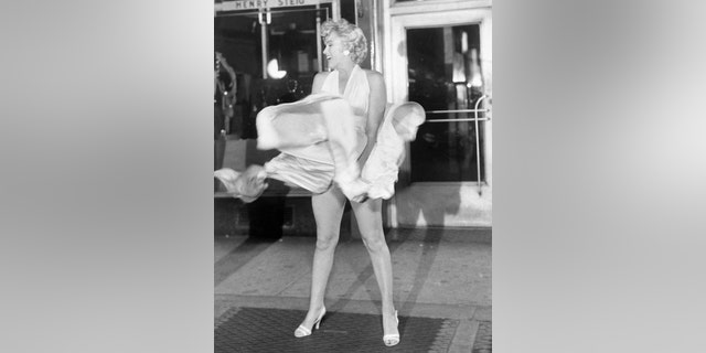 Marilyn Monroe is seen here trying to hold down her dress as wind from a subway grate blows it upward during filming of "The Seven Year Itch" in Manhattan.