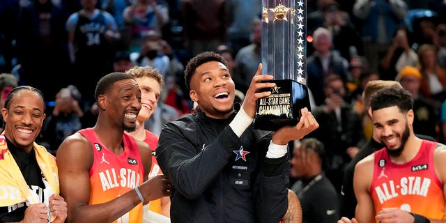 Giannis Antetokounmpo holds up the winning team's trophy after the NBA basketball All-Star game on Sunday, February 19, 2023, in Salt Lake City.