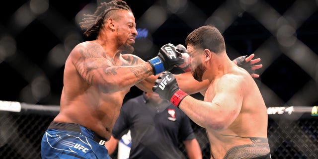 Greg Hardy (L) and Tai Tuivasa of Australia exchange punches in the first round in their heavyweight bout during UFC 264: Poirier vs. McGregor 3 at T-Mobile Arena on July 10, 2021, in Las Vegas, Nevada.