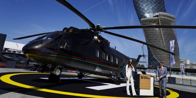 Russian salespeople stand by a helicopter at the International Defense Exhibition and Conference in Abu Dhabi, United Arab Emirates, on Feb. 20, 2023. 
