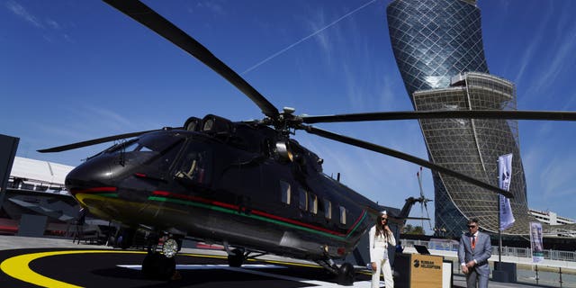 Russian salespeople stand by a helicopter at the International Defense Exhibition and Conference in Abu Dhabi, United Arab Emirates, on Feb. 20, 2023.