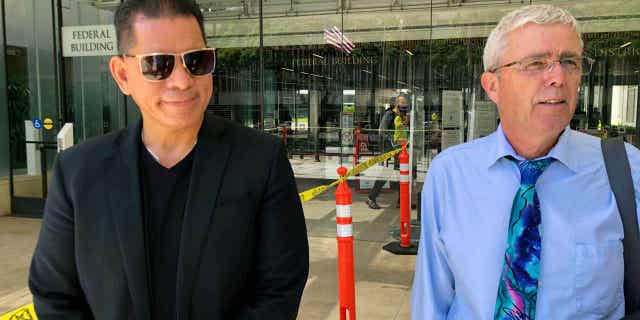 Stewart Olani Stant, left, listens while his attorney speaks to reporters in Honolulu on Sept. 19, 2022. Stant was sentenced on Feb. 8, 2023, to 10 years in prison for accepting bribes from a Honolulu businessman.