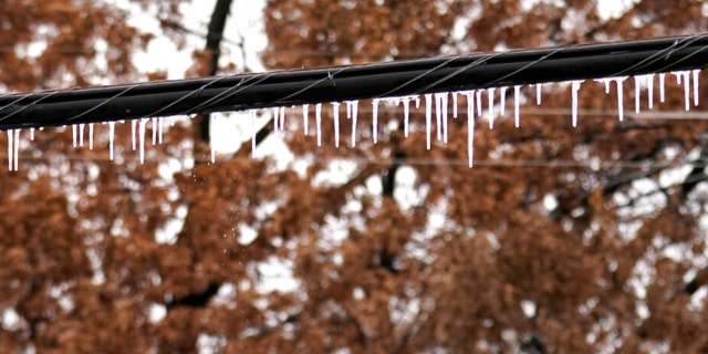 Icicles coat and hang off an electrical line after a few days of sleet and snow, Thursday, Feb. 2, 2023, in Richardson, Texas.