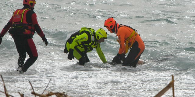 Crews recover a body near Cutro, southern Italy, Sunday, Feb. 26, 2023. 