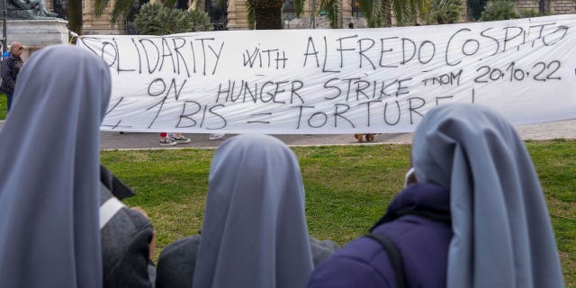 Three nuns watch at a banner in solidarity with Alfredo Cospito being displayed in front of the Italian Cassation Court in Rome, on Feb. 24, 2023, while the case of anarchist Alfredo Cospito, who has been on a hunger strike since October to protest a strict prison regime reserved for terrorists and mafiosi, is being discussed.