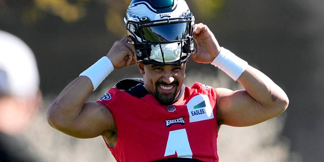 Philadelphia Eagles quarterback Jalen Hurts puts on his helmet during practice, Thursday, Feb. 9, 2023, in Tempe.