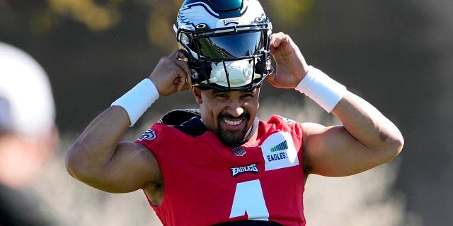 El mariscal de campo de los Philadelphia Eagles, Jalen Hurts, se pone el casco durante la práctica, el jueves 9 de febrero de 2023, en Tempe.