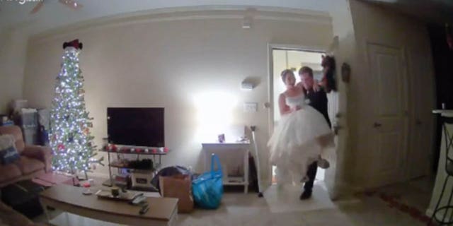 Alex Herrig can be seen carrying his new bride, dressed in a white wedding gown, through the front door of their home. The sweet moment was caught on their indoor camera.