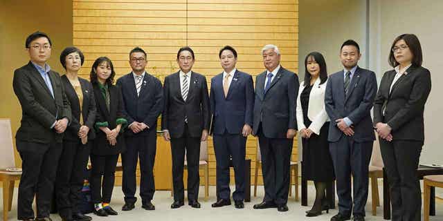 Japanese Prime Minister Fumio Kishida, center left, poses with the leaders of LGBTQ groups. Kishida apologized to the leaders over his former aide’s discriminatory remarks at the prime minister's office in Tokyo on Feb. 17, 2023.