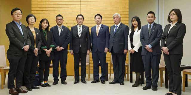 Japanese Prime Minister Fumio Kishida, center left, poses with the leaders of LGBTQ groups. Kishida apologized to the leaders over his former aide’s discriminatory remarks at the prime minister's office in Tokyo on Feb. 17, 2023.