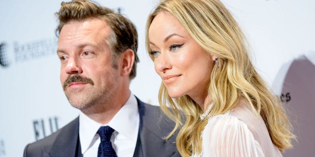 Jason Sudeikis and Olivia Wilde smile for a photo