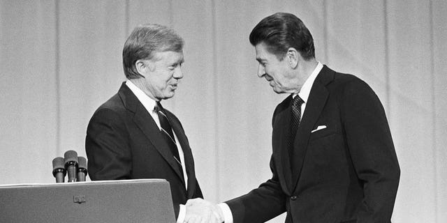 President Jimmy Carter and his Republican challenger, Ronald Reagan, shake hands as they greet one another before their debate on the stage of the Music Hall in Cleveland, Ohio.