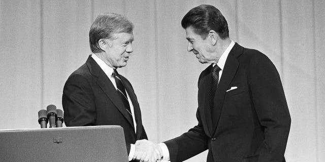 President Jimmy Carter and his Republican challenger, Ronald Reagan, shake hands as they greet one another before their debate on the stage of the Music Hall in Cleveland, Ohio.