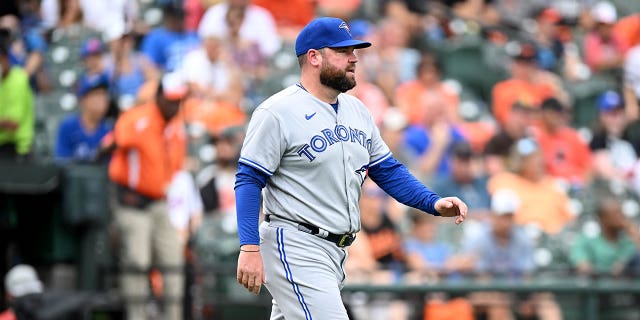 El gerente interino de los Toronto Blue Jays, John Schneider #14, cruza el campo durante el juego contra los Orioles de Baltimore en el Oriole Park en Camden Yards en el Juego 1 de un doble título el 5 de septiembre de 2022 en Baltimore, Maryland.