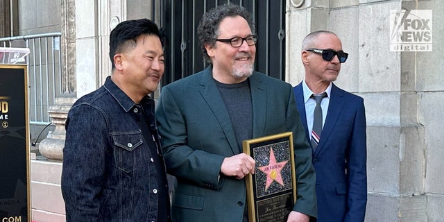 Robert Downey Jr., right, praised Jon Favreau, center, on the Walk of Fame stage, saying the famed director was always searching for how to make things better.