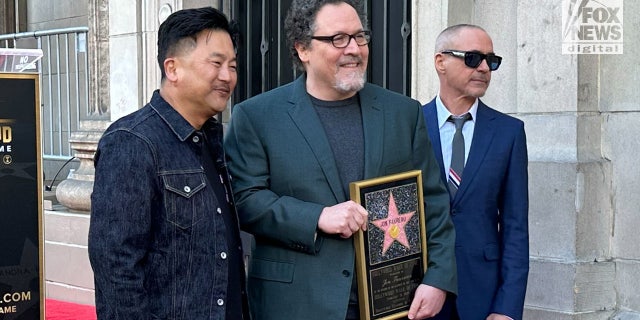 Robert Downey Jr., right, praised Jon Favreau, center, on the Walk of Fame stage, saying the famed director was always searching for how to make things better.