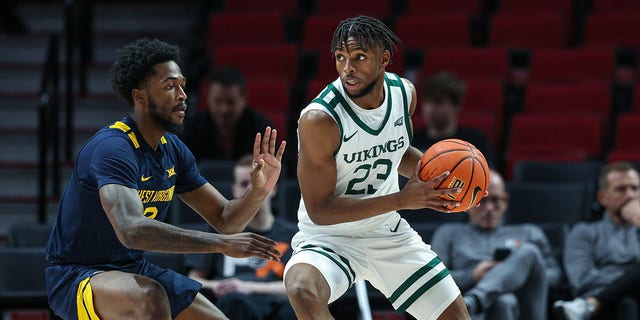 Jorrell Satterfield (23) of the Portland State Vikings handles the ball against Kobe Johnson (2) of the West Virginia Mountaineers at Moda Center on November 25, 2022 in Portland, Ore.