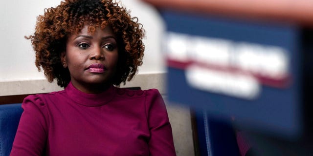 White House press secretary Karine Jean-Pierre listens as National Economic Council director Brian Deese speaks during the daily briefing at the White House in Washington.