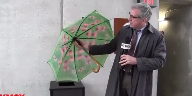 Kevin Killeen of St Louis’ KMOX picks up a discarded broken umbrella during a dreary day in February. 