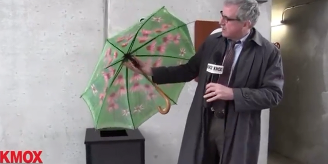 Kevin Killeen of St Louis’ KMOX picks up a discarded broken umbrella during a dreary day in February.