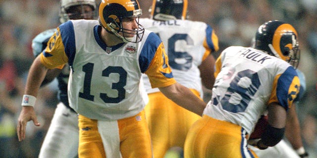 Kurt Warner of the St. Louis Rams passes the ball to Marshall Faulk against the Tennessee Titans during Super Bowl XXXIV at the Georgia Dome on January 30, 2000, in Atlanta.