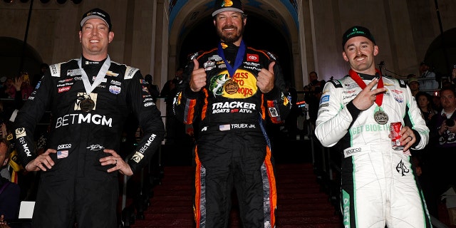 Martin Truex Jr., conductor del Toyota Bass Pro Shops n.° 19, (C) ganador, Austin Dillon, conductor del Chevrolet Get Bioetanol n.° 3, (L) segundo lugar y Kyle Busch, conductor del Chevrolet BetMGM n.° 8, tercero posa para las fotos en el podio después del Choque de NASCAR en el Coliseo del Los Ángeles Memorial Coliseum el 5 de febrero de 2023 en Los Ángeles.