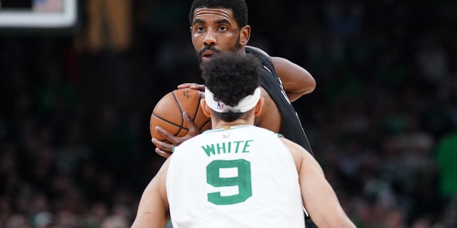 Brooklyn Nets defender Kyrie Irving, #11, looks for an opening against Boston Celtics defender Derrick White, #9, successful nan 2nd half astatine TD Garden successful Boston Feb. 1, 2023.
