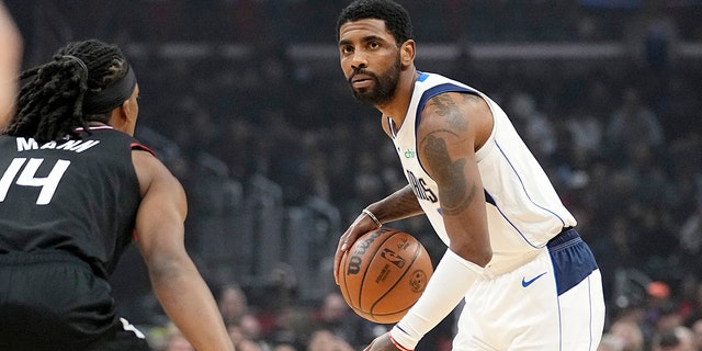 Dallas Mavericks guard Kyrie Irving, right, dribbles as Los Angeles Clippers guard Terance Mann defends during the first half of a game on February 8, 2023 in Los Angeles. 