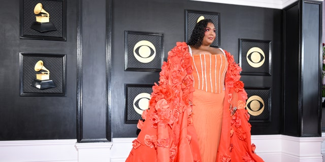 Lizzo revealed a stunning structured gown underneath her flowing cape as she walked the red carpet.